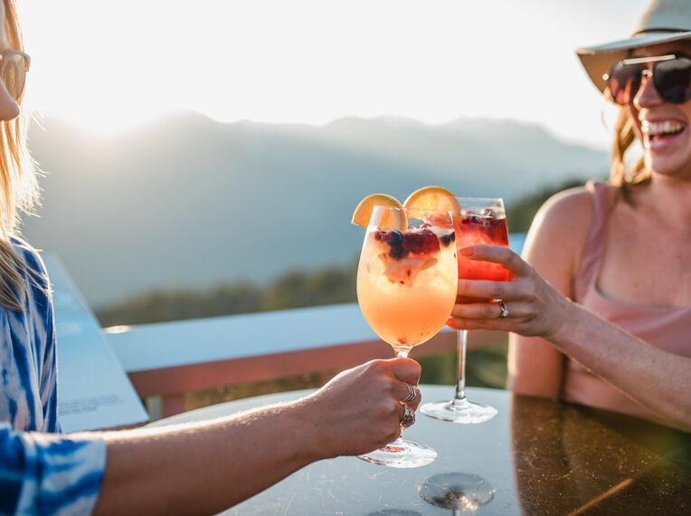 Two women enjoying a sunset beverage at Sea to Sky Gondola