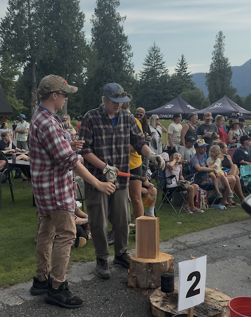 two people standing over a piece of wood