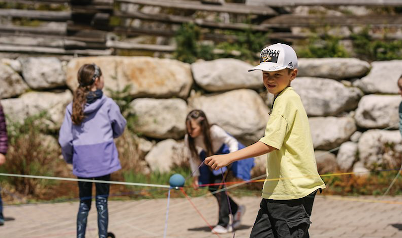 a student playing a game including a ball and string