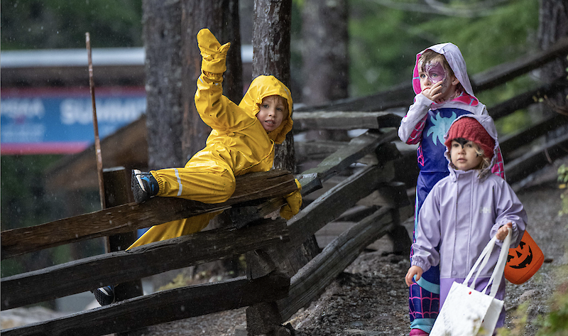 three children trick-or-treating on a trail