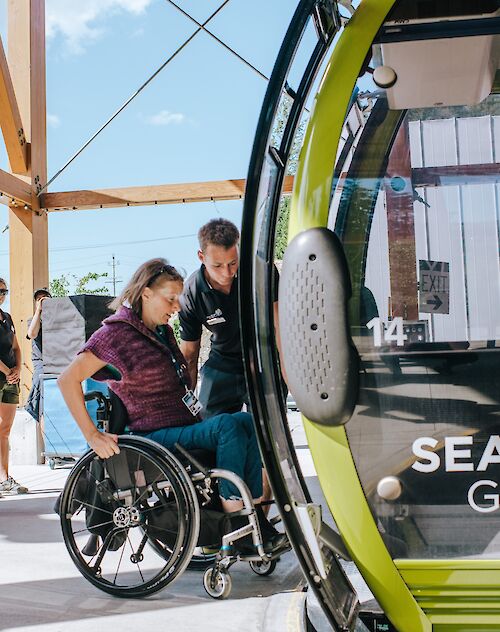 a lady in a wheelchair getting on the gondola