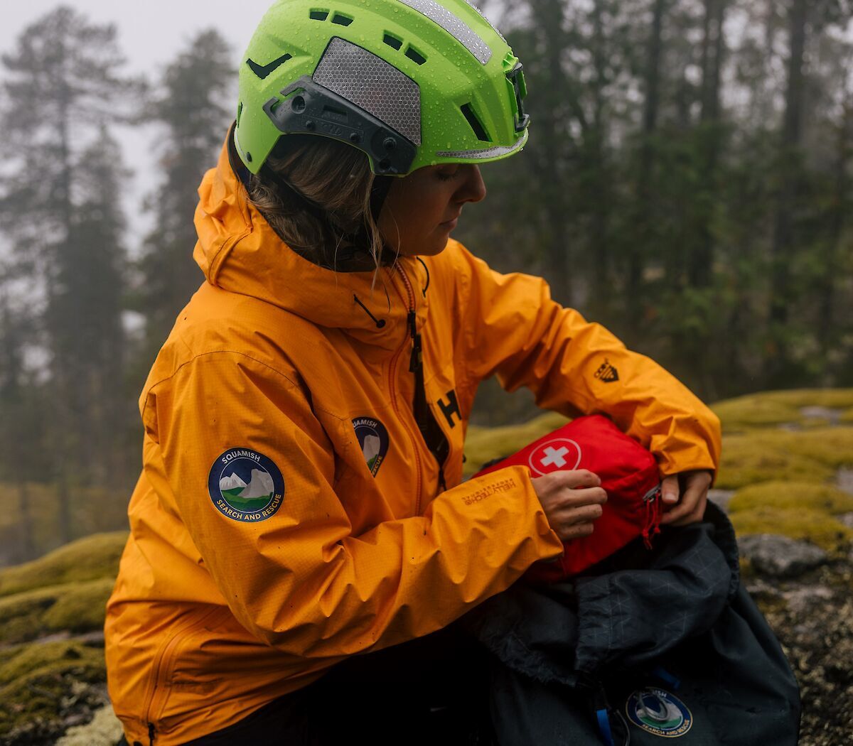 a lady holding a first aid pouch on a mountain