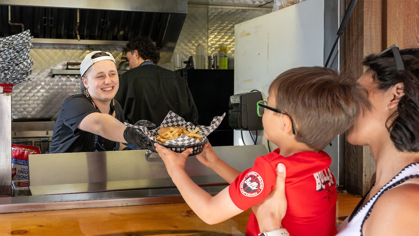 A mom and son receiving a burger