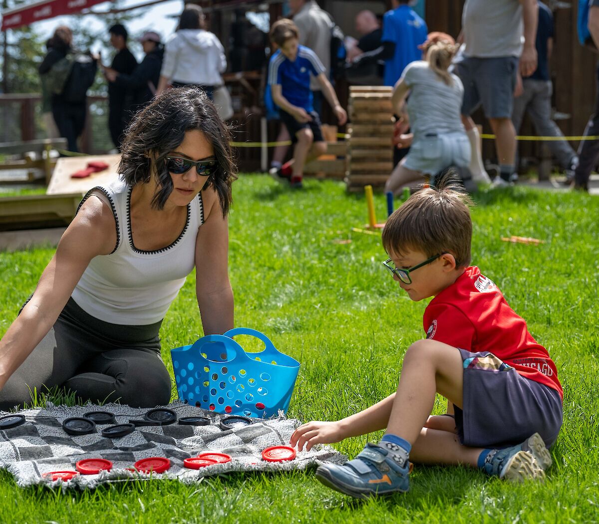 A mom and son playing lawn checkers