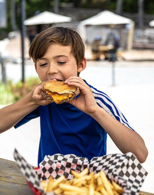 a boy eating a burger