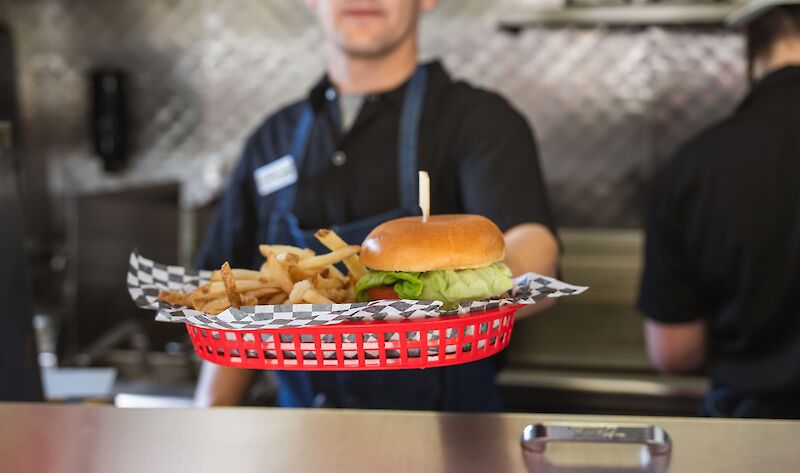 A person holding a burger