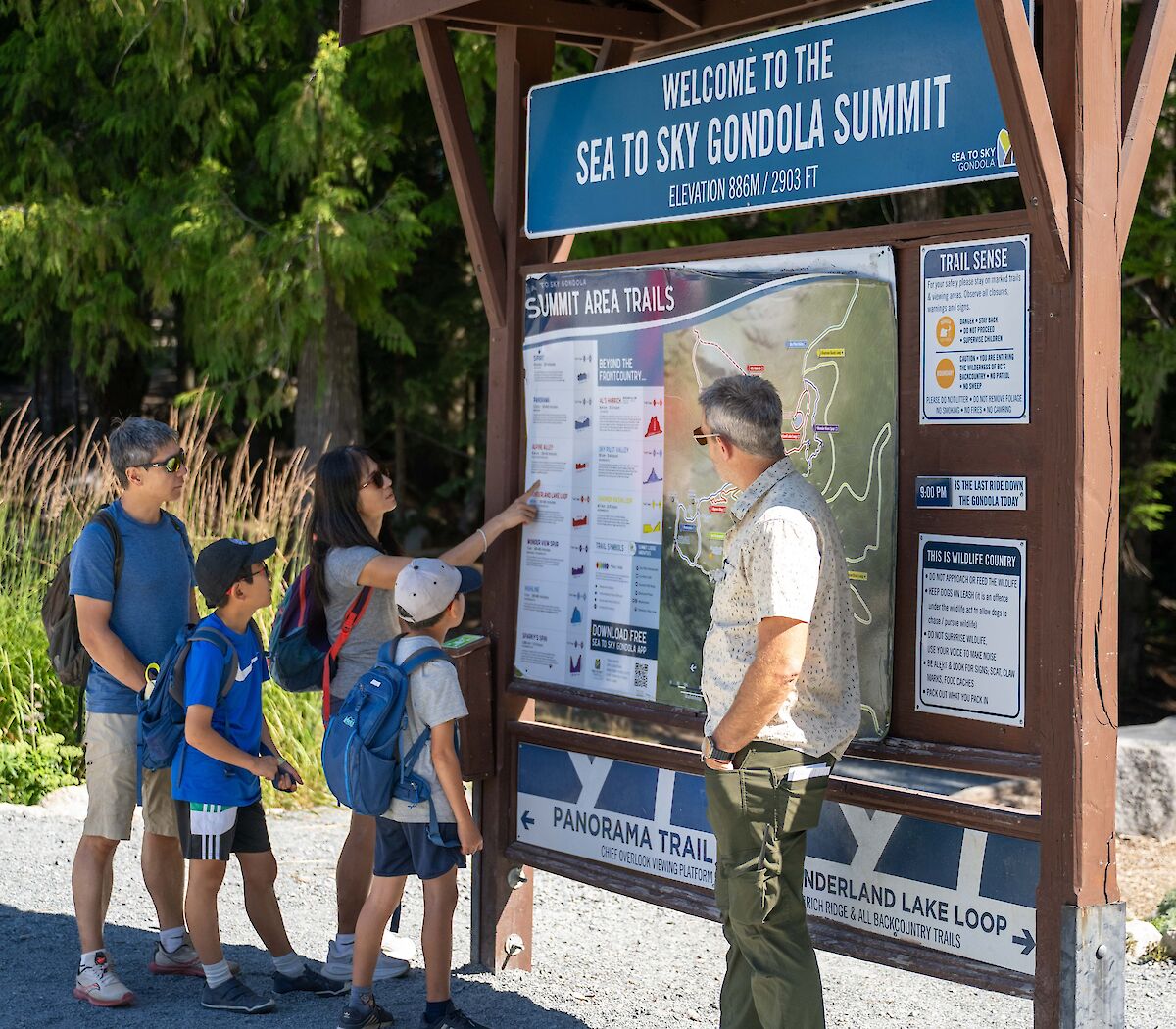 A guide and a family standing at a map board