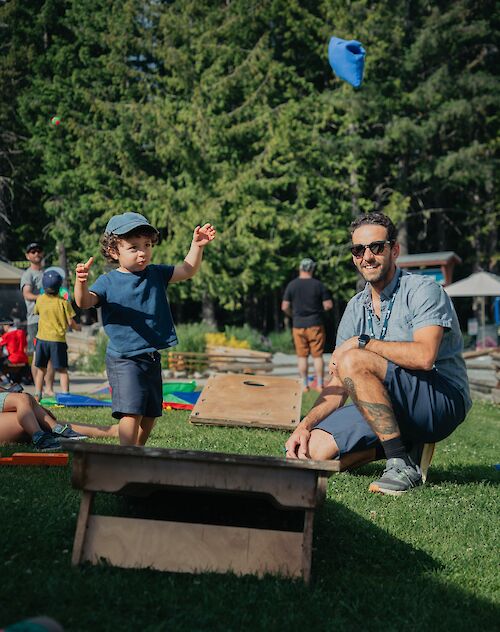 a child and father playing games on the lawn