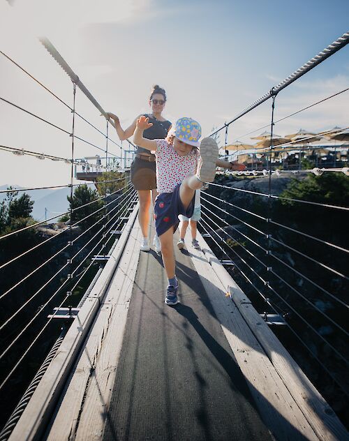 a mother and daughter on the suspension bridge