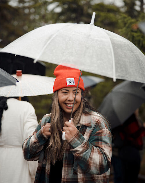 a women standing under an umbrella smiling