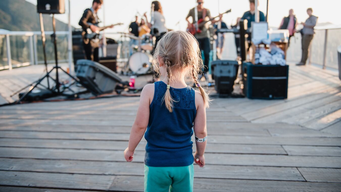 a little girl watching a band perform on the octagon deck