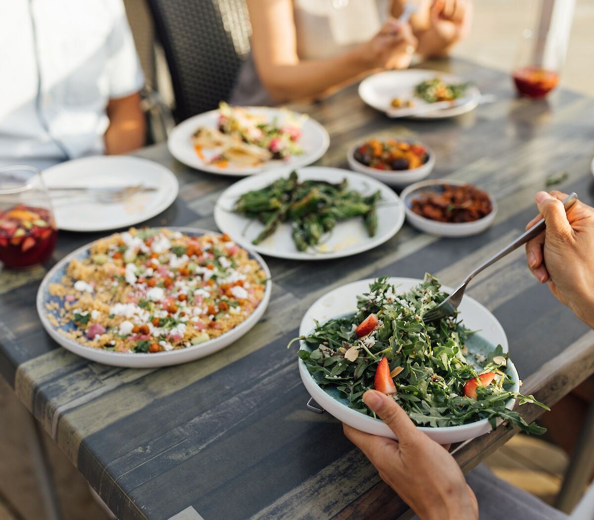 a girl holding a plate of salad