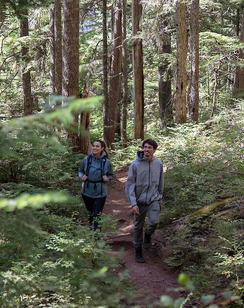 two people walking on a trail