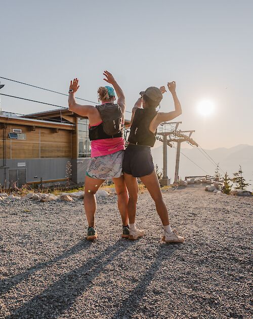 two women hikers bumping hips