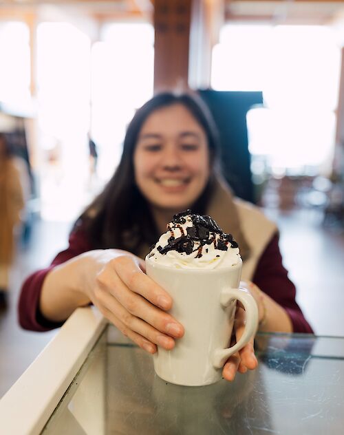 a girl grabbing a hot chocolate