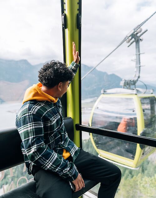 a man waving to another gondola cabin