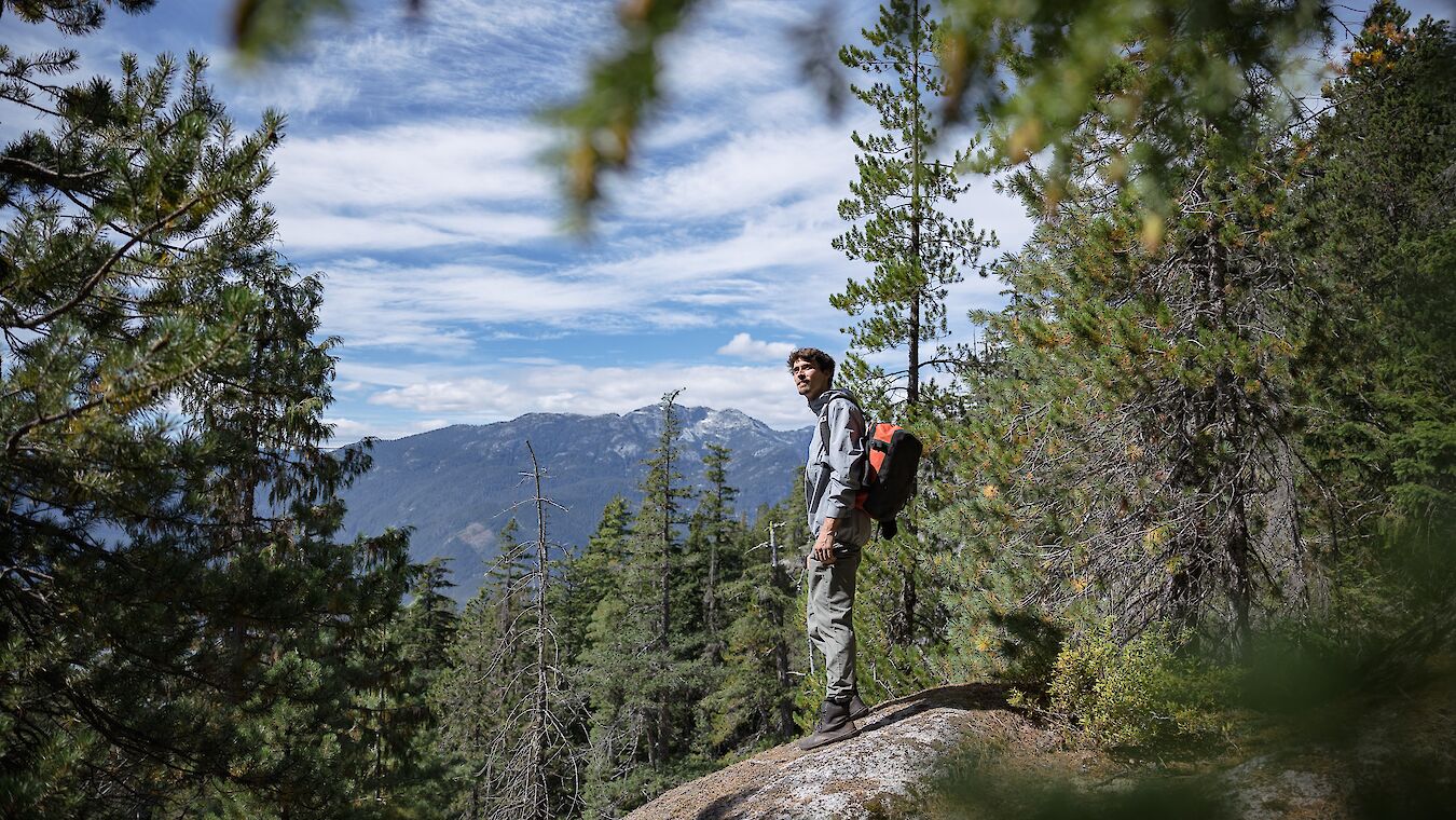 a man standing on a rock looking out at a view