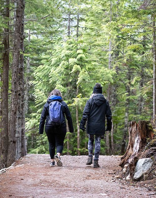 two people walking on a trail