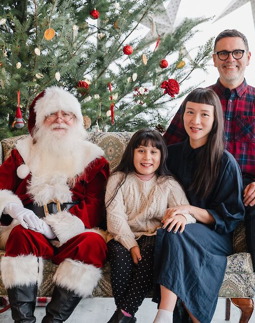 A family posing for a picture with Santa